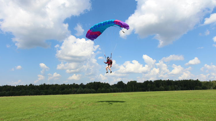 Person landing with a parachute.