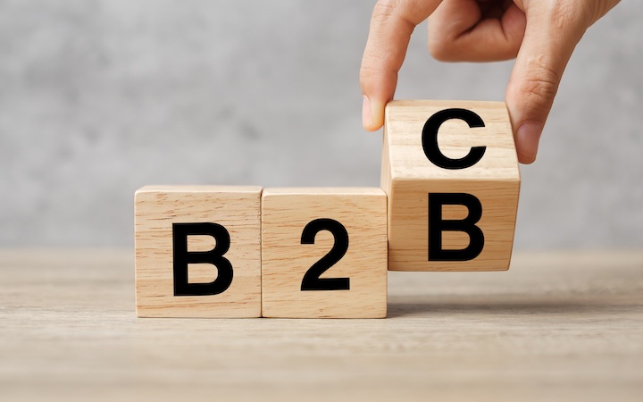 A hand changes wooden cube block from B2C to B2B.