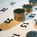 Stacks of quarters sit on top squares of a calendar.